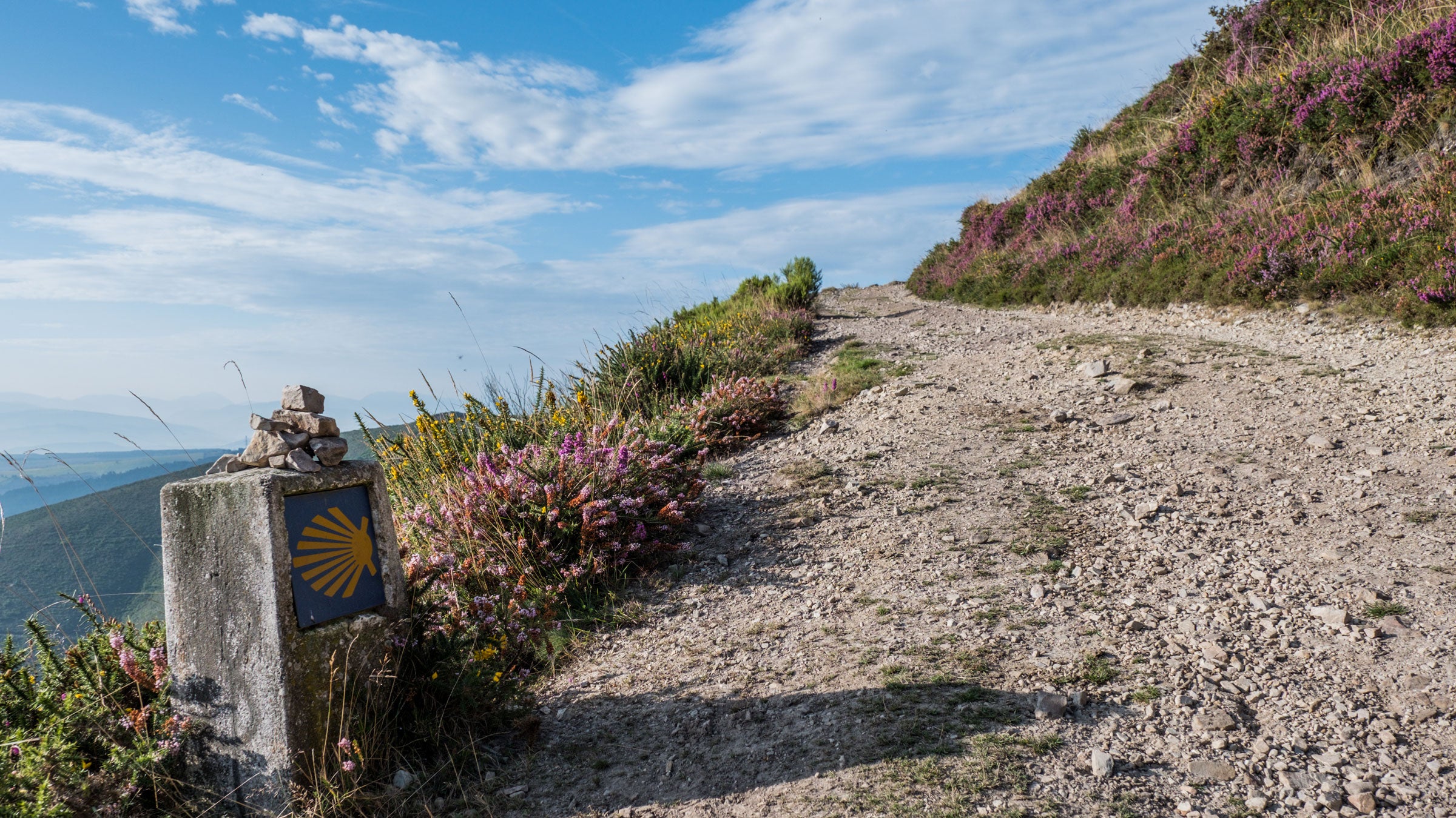 Pilgrims walking the Camino de Santiago trail through Spanish countryside